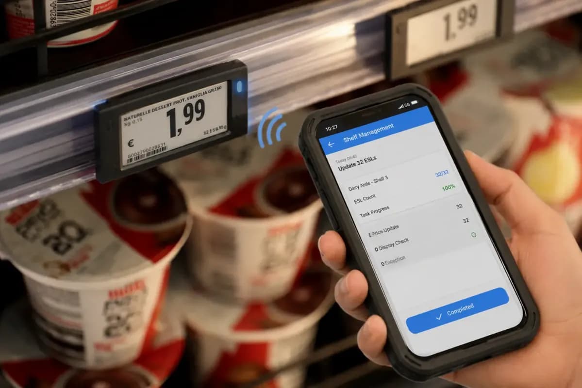 Employé qui met à jour les étiquettes d’un rayon depuis l’application mobile